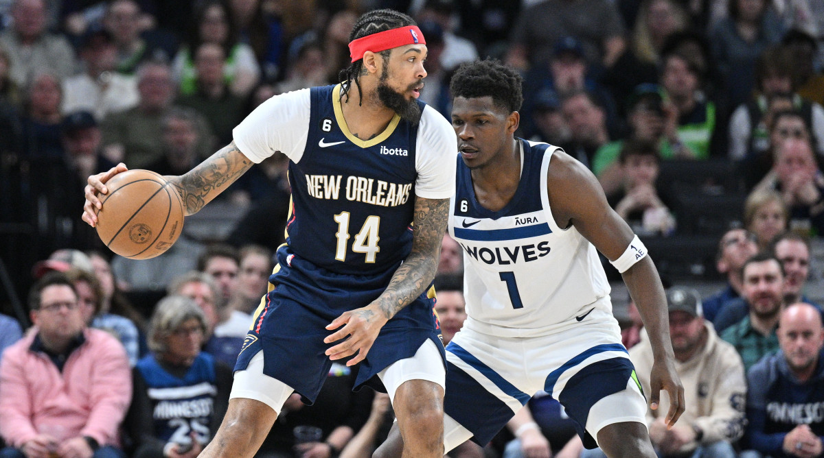 Pelicans forward Brandon Ingram (14) controls the ball as Timberwolves guard Anthony Edwards (1) defends during the last game of the 2022-23 regular season